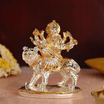 Gold and silver plated idol of Goddess Durga seated majestically on her lion mount.