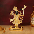 A gold-plated idol of Lord Shreenath Ji (a form of Lord Krishna) with a dark-faced deity and a raised left hand, symbolizing the lifting of Govardhan Hill, set against a dark reddish-brown background.