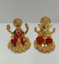 A pair of polyresin gold-plated statues depicting Goddess Lakshmi and Lord Ganesha, seated on elaborate golden bases with red and green accents on their attire.
