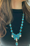 A long necklace with a multi-stone design featuring blue beads, strung together on a chain.