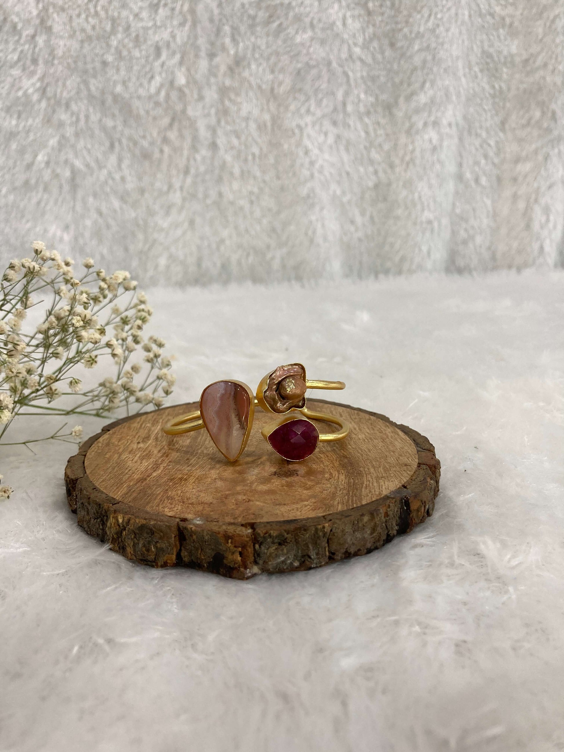 Pink Stone adjustable ear cuff on the wooden base