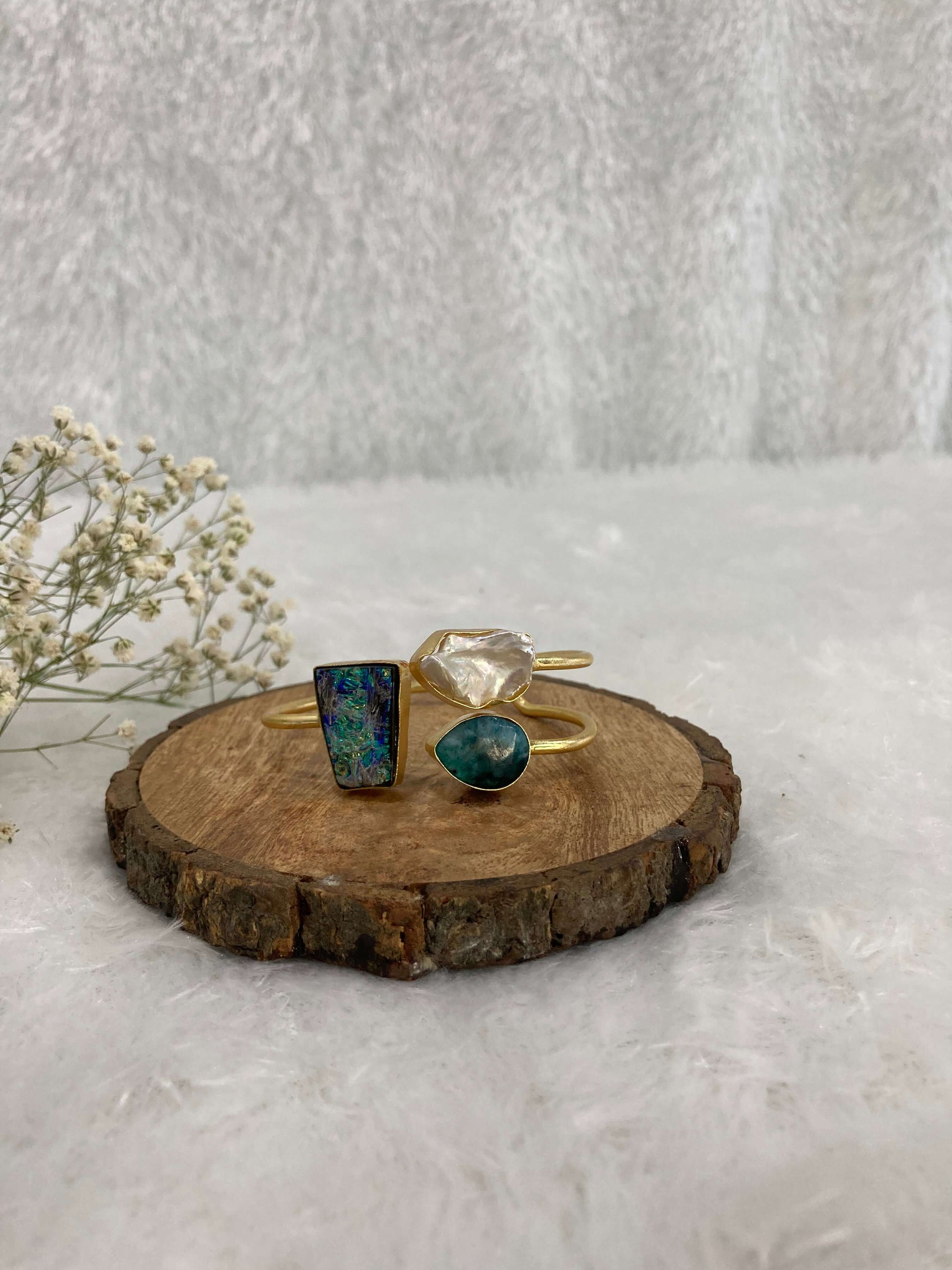 white and multicolor Stone adjustable ear cuff on the wooden base