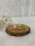 white Stone ear cuff on the wooden base