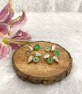 Six white and green stone earrings on the wooden base