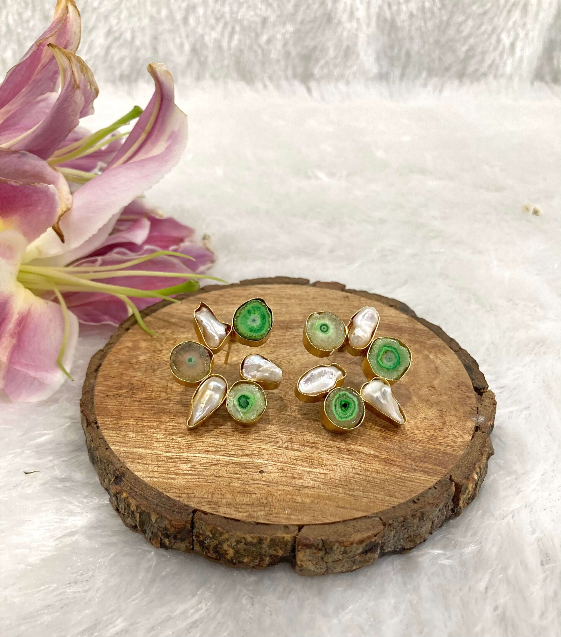 Six white and green stone earrings on the wooden base