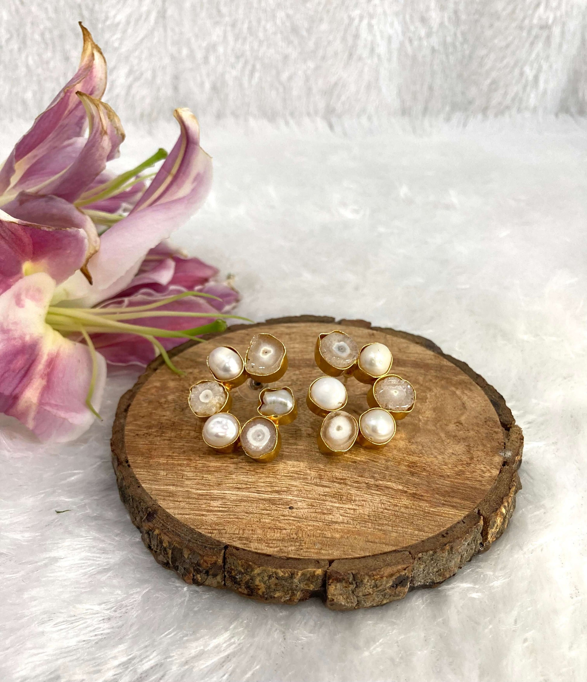 Six white earrings on the wooden base