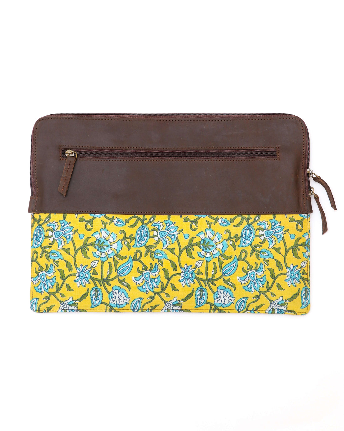 A leather laptop sleeve with a yellow floral block print on the lower half and a solid brown upper half, zipped closed.
