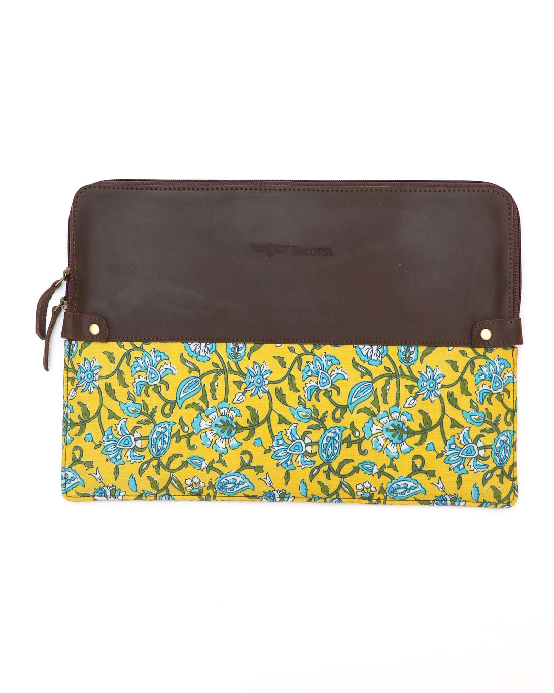 A leather laptop sleeve with a yellow floral block print on the lower half and a solid brown upper half, zipped closed.
