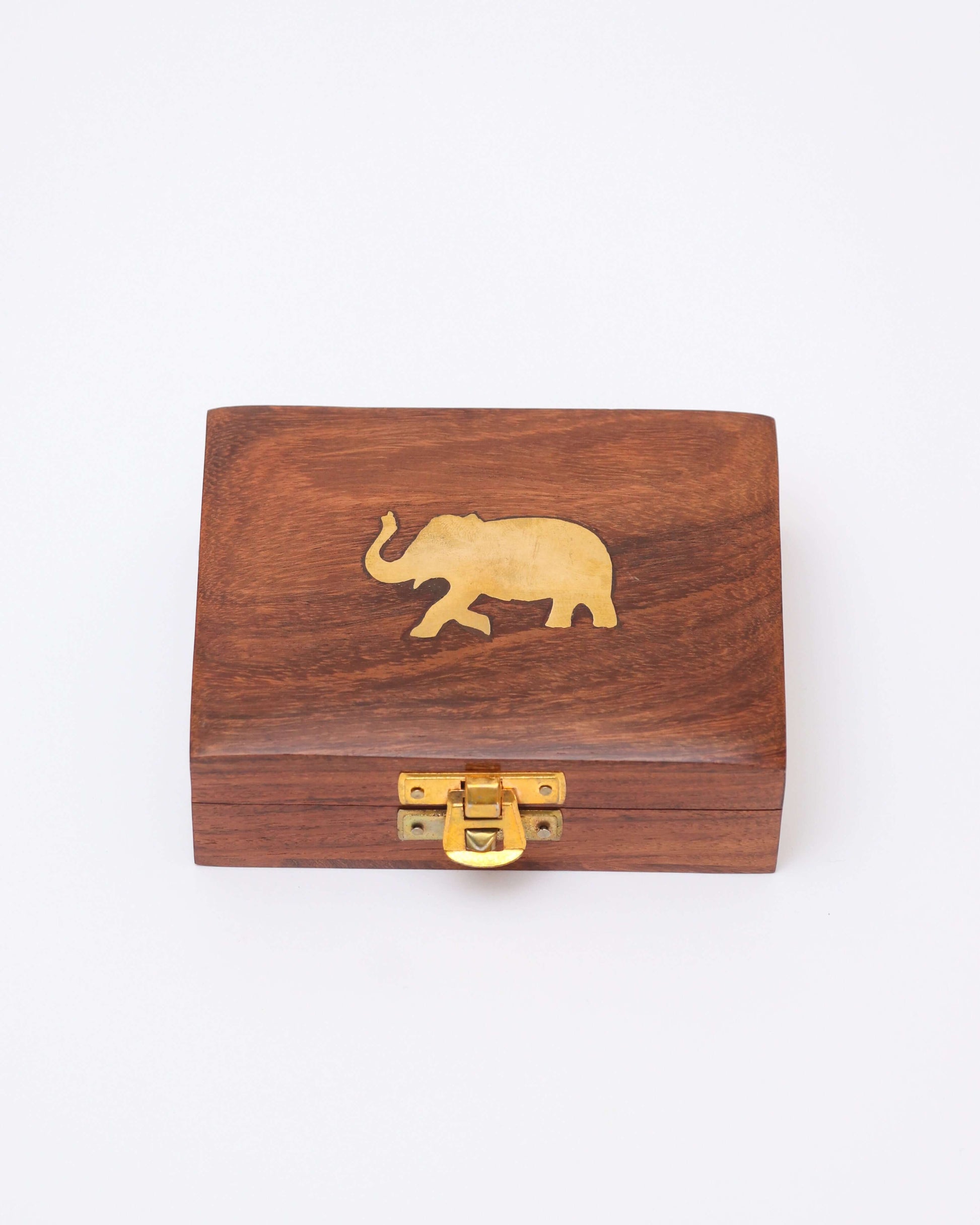 A small, rectangular, handcrafted wooden jewelry box with a brass latch on the front and a brass elephant inlaid on the lid. The wood has a natural grain and a polished finish.