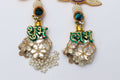 A pair of decorative Shubh Labh door hangings, featuring a beaded lotus design with a small peacock motif and a circular yellow backing. Below the lotus, a dangling silver bell-shaped piece is decorated with a green text