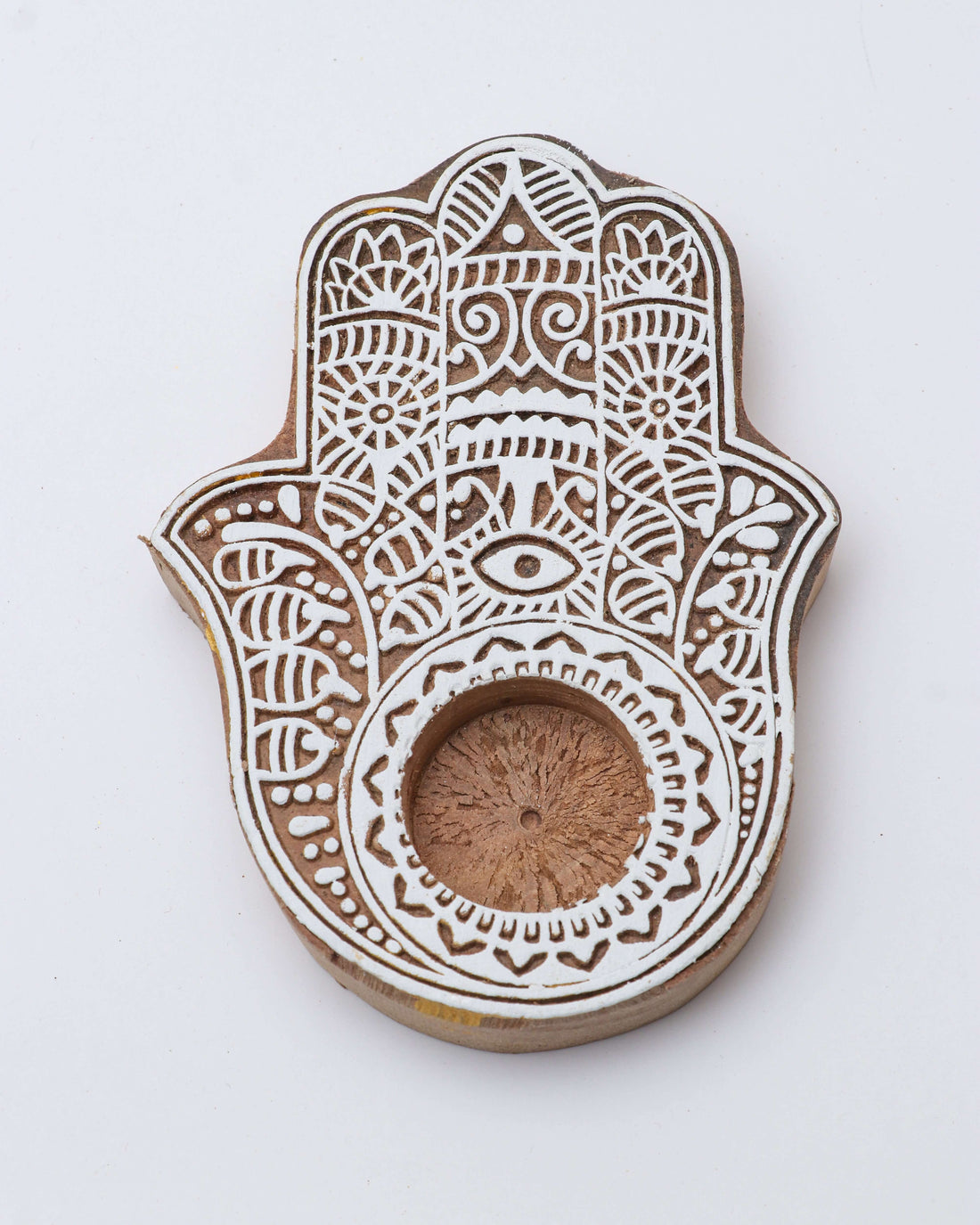 A wooden tealight holder with a floral pattern and a central opening for the candle.
