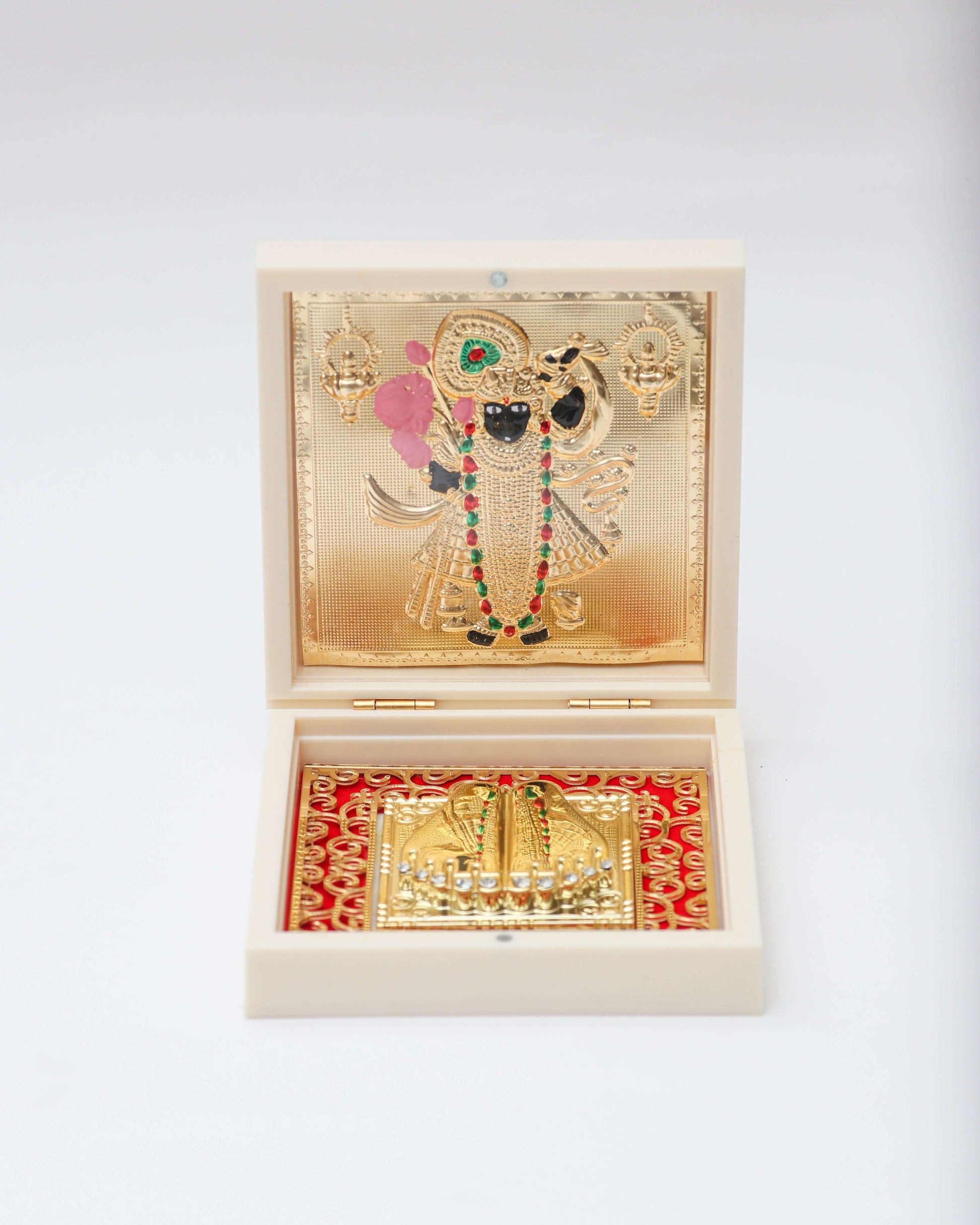Golden framed picture of Shreenathji and Charan Paduka in a white wooden box with red fabric lining.
