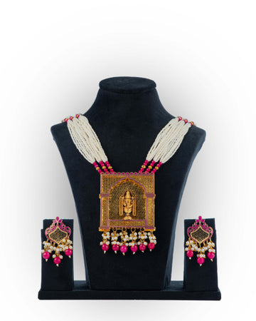 A jewelry set featuring a necklace with pink blossom pendants and a matching pair of earrings, displayed on a mannequin bust.