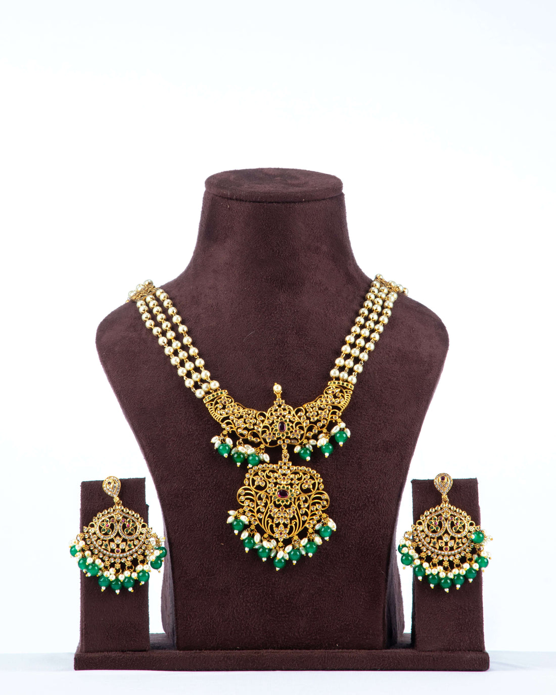 A necklace set with white pearl cascade design and green pearl pendant, displayed on a mannequin bust.