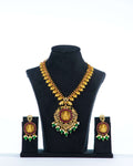 A South Indian coin necklace with a Goddess Laxmi pendant displayed on a mannequin bust, accompanied by a pair of matching earrings.
