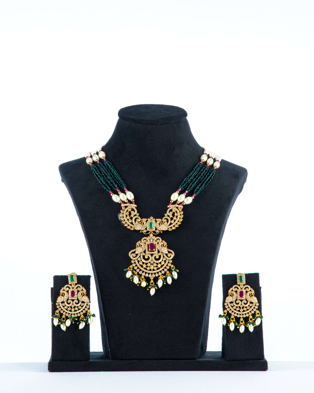 A mannequin showcasing a green and white long Raani haar set, with multiple layers of beads and pearls, along with earrings.