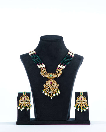 A mannequin showcasing a green and white long Raani haar set, with multiple layers of beads and pearls, along with earrings.