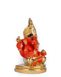 A red and gold statue of Lord Ganesha, specifically a Siddhivinayak idol, sitting on a golden base.