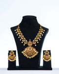 A multi-color polki necklace set with gold plating, pearls, and intricate designs displayed on a black mannequin bust with a pair of matching earrings.