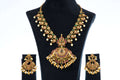 A multi-color Polki necklace set with matching earrings is displayed on a black jewelry stand. The set is gold-toned and features a large, intricately designed pendant with green and red stones, surrounded by dangling white pearls. The matching chandelier-style earrings have the same stone and pearl design.