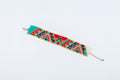 A colorful beaded bracelet on the white base