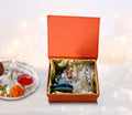 A rakshabandhan orange hamper open box with pooja thali
