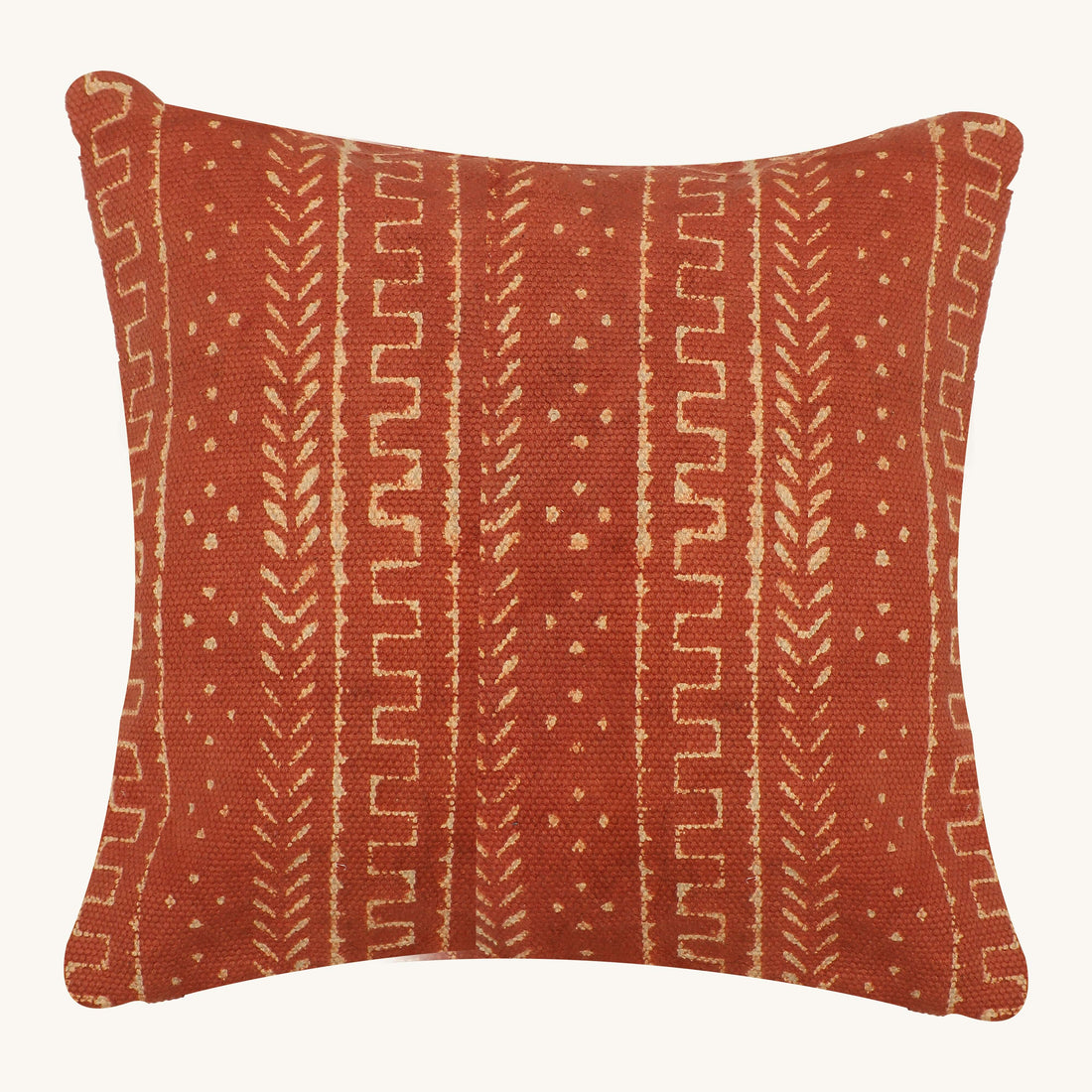 A cushion cover with a rust mudcloth block print pattern, displayed on a yellow sofa.