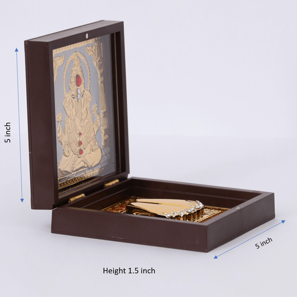 Open dark brown wooden box revealing a gold-plated Lord Ganesh idol and sacred Charan Paduka inside. The box measures 5 inches by 5 inches with a height of 1.5 inches.