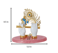A gold-plated Lord Krishna Hands Idol featuring a peacock feather and a flute. The idol stands 4.5 inches tall and 5.0 inches wide at the base, with a hand span of 3.0 inches as indicated by dimension lines. It is set on a pink, oval-shaped base.