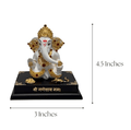 A white and gold Ganesha idol sitting on a black base, approximately 4.5 inches tall and 3 inches wide. The idol features red jewels, and the base has the Sanskrit phrase 'शà¥à¤°à¥€ गणेशाय नमः' (Shri Ganeshaya Namah) written in gold.