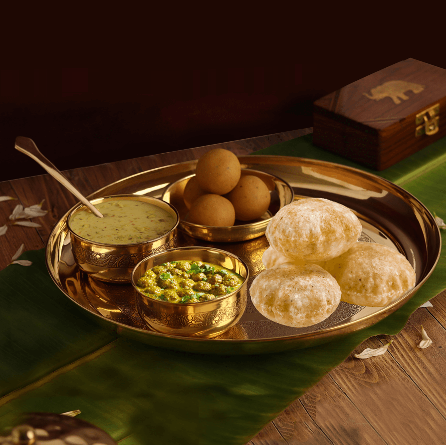 Brass Bhog Thali with besan laddo, rasmalai in bowl, chana sabji with puri