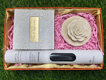 A gift set containing an incense tube, a ceramic rose incense holder, and a Ganesha-Lakshmi pocket temple, all presented in a gift box with a pink interior.