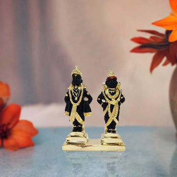 A pair of black and gold polyresin idols depicting the Hindu deities Lord Vitthal and Goddess Rukmini (Rakhumai), adorned with intricate gold-plated jewelry and crowns, standing on a golden base.
