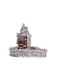 A silver-plated idol of the Mahakaleshwar Jyotirlinga, depicting the fierce form of Lord Shiva with a dark face and traditional markings, resting on an ornate silver base.