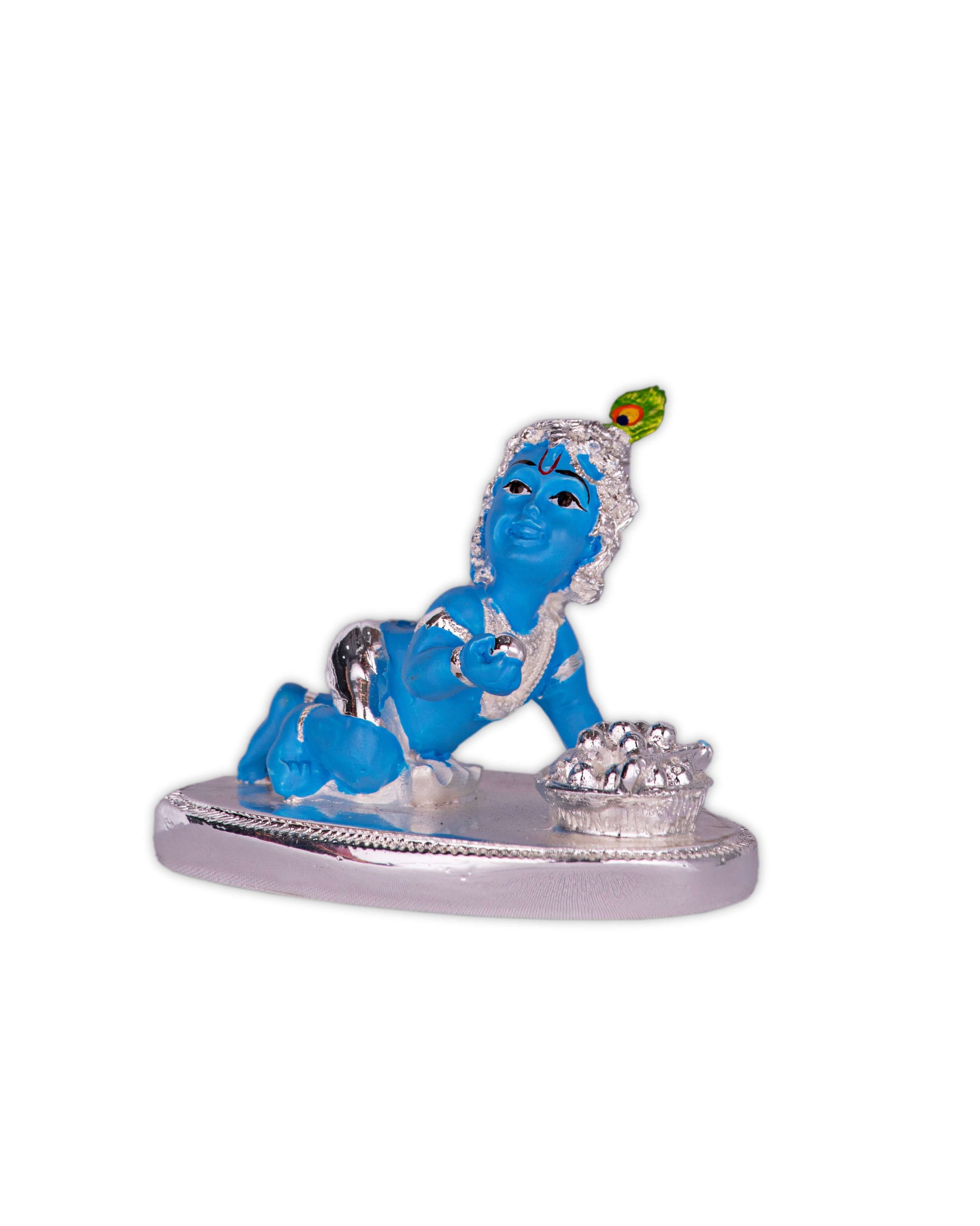 An image of a vibrant blue Bal Krishna (Laddu Gopal) idol in a crawling pose on a silver base, with a silver pot of butter (Makhan Handi) beside him. He is adorned with silver ornaments and a peacock feather on his head.