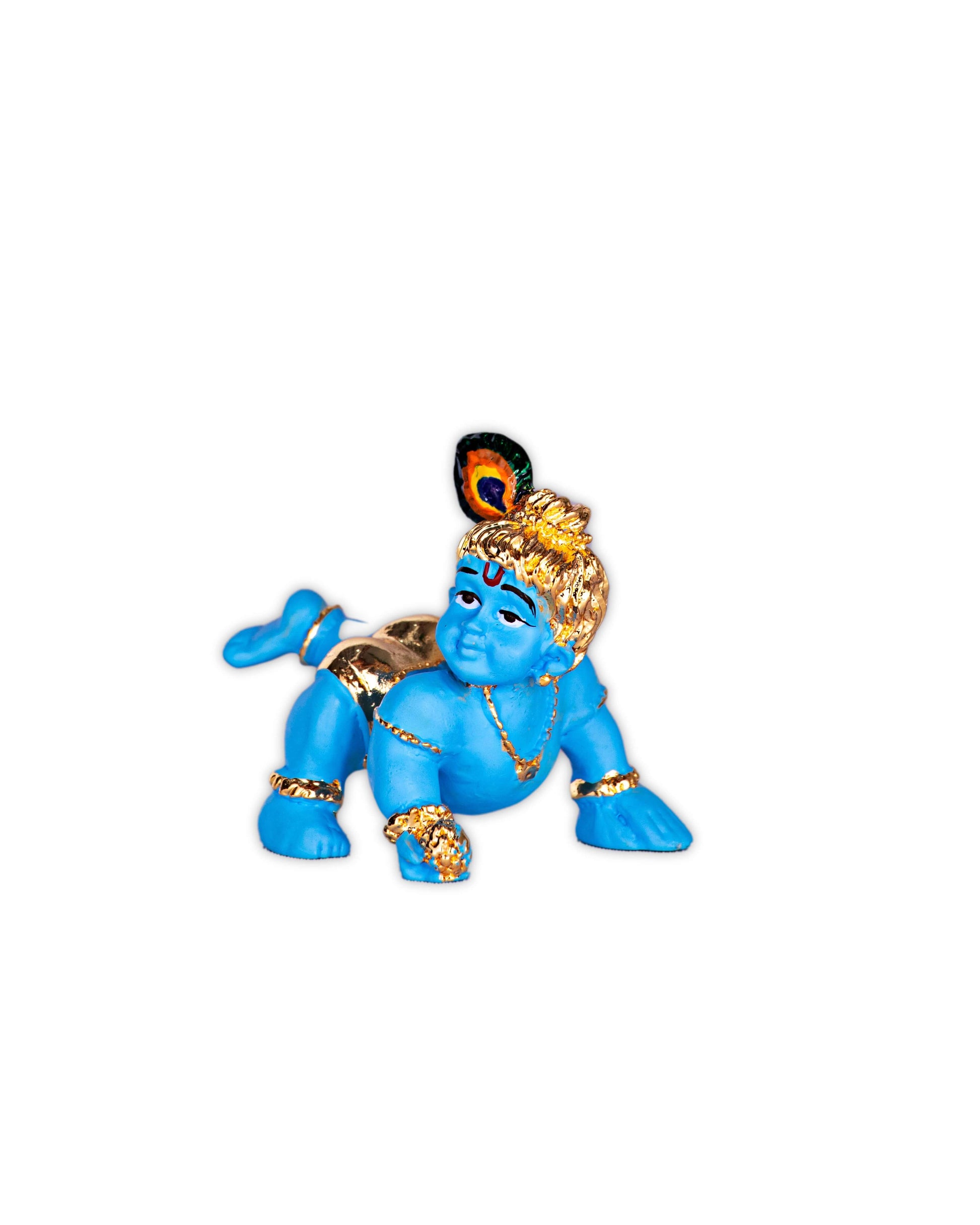 A blue idol of infant Lord Krishna, also known as Laddu Gopal or Bala Krishna, in a crawling pose on a white background. The idol is adorned with golden jewelry and a peacock feather on its head, depicting the playful and divine child form of Lord Krishna.