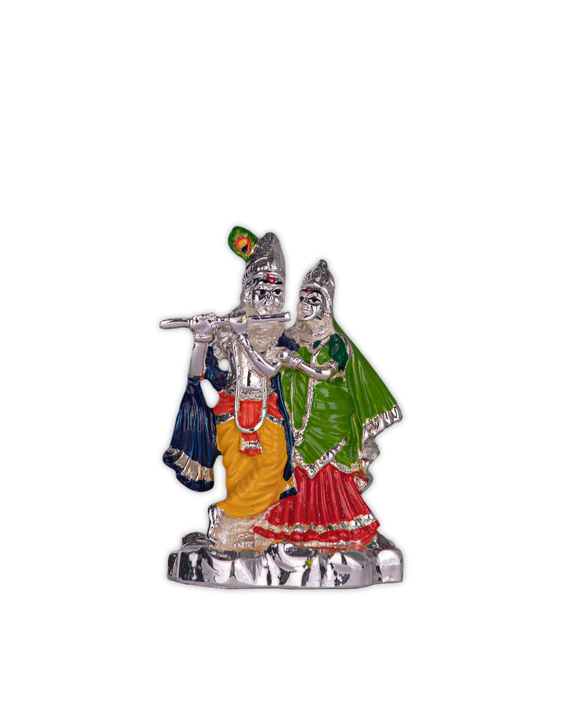 A silver-colored statue of Radha and Krishna, with Krishna playing a flute adorned with a peacock feather, and Radha standing beside him, both figures wearing traditional attire with colorful accents.
