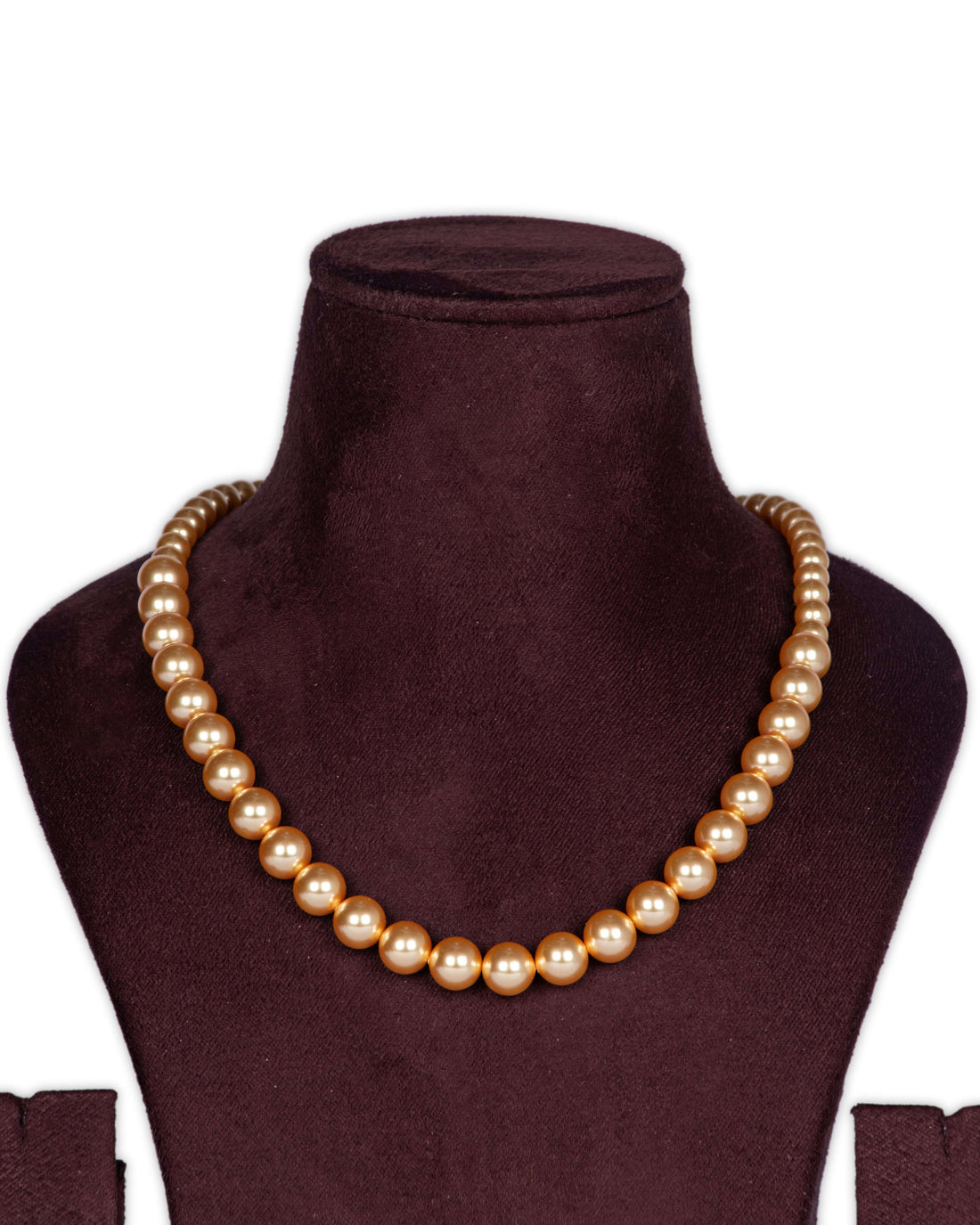 A gold-colored necklace featuring a string of pearls displayed on a mannequin bust.