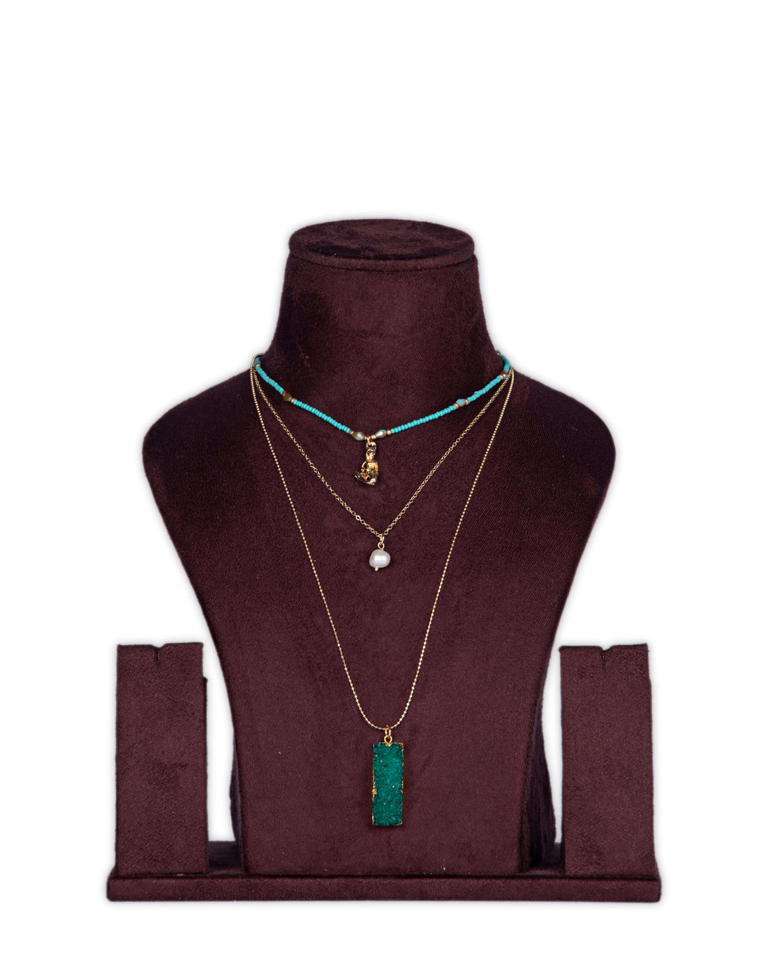 A display of layered necklaces with a prominent green agate pendant as the focus, set on a mannequin bust.