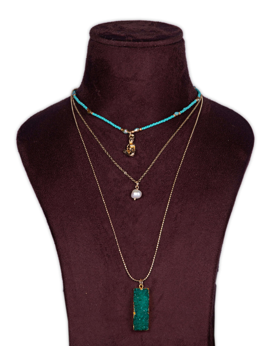 A display of layered necklaces with a prominent green agate pendant as the focus, set on a mannequin bust.