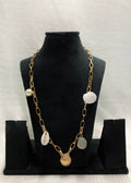 A necklace with gold chain and aqua semi-precious charm shells along with a baroque pearl, displayed on a mannequin.