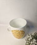 white mug with yellow design on it