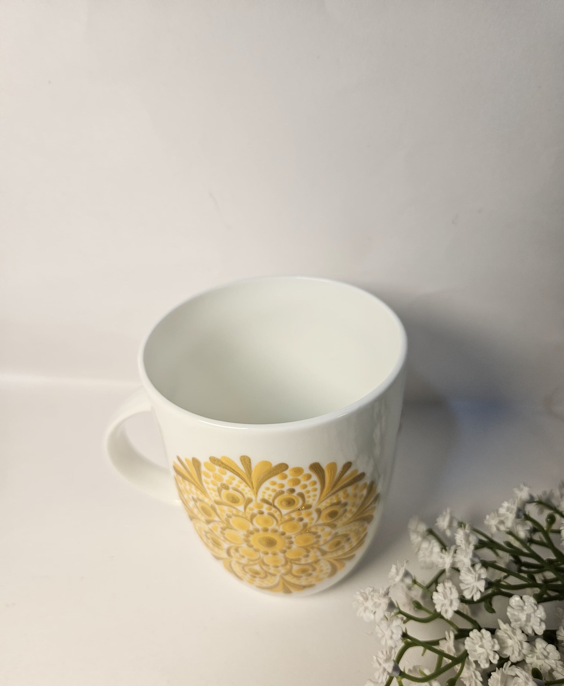 white mug with yellow design on it