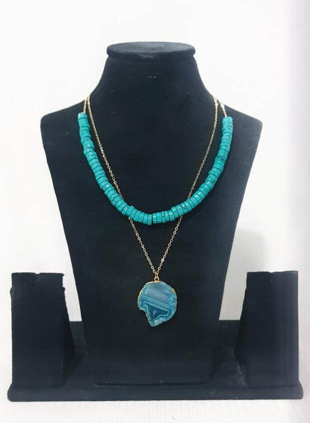 Aqua semi-precious agate stone necklace with a light gold finish displayed on a mannequin bust.
