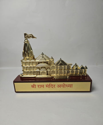 Golden replica of the intricately designed Shree Ram Mandir (Ayodhya) temple model, sitting on a red base with the text "श्री राम मंदिर अयोध्या" in Hindi.