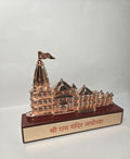 Rose gold metallic idol of the Ram Mandir Ayodhya, a spiritual souvenir or decorative piece, on a brown rectangular base with Hindi script.