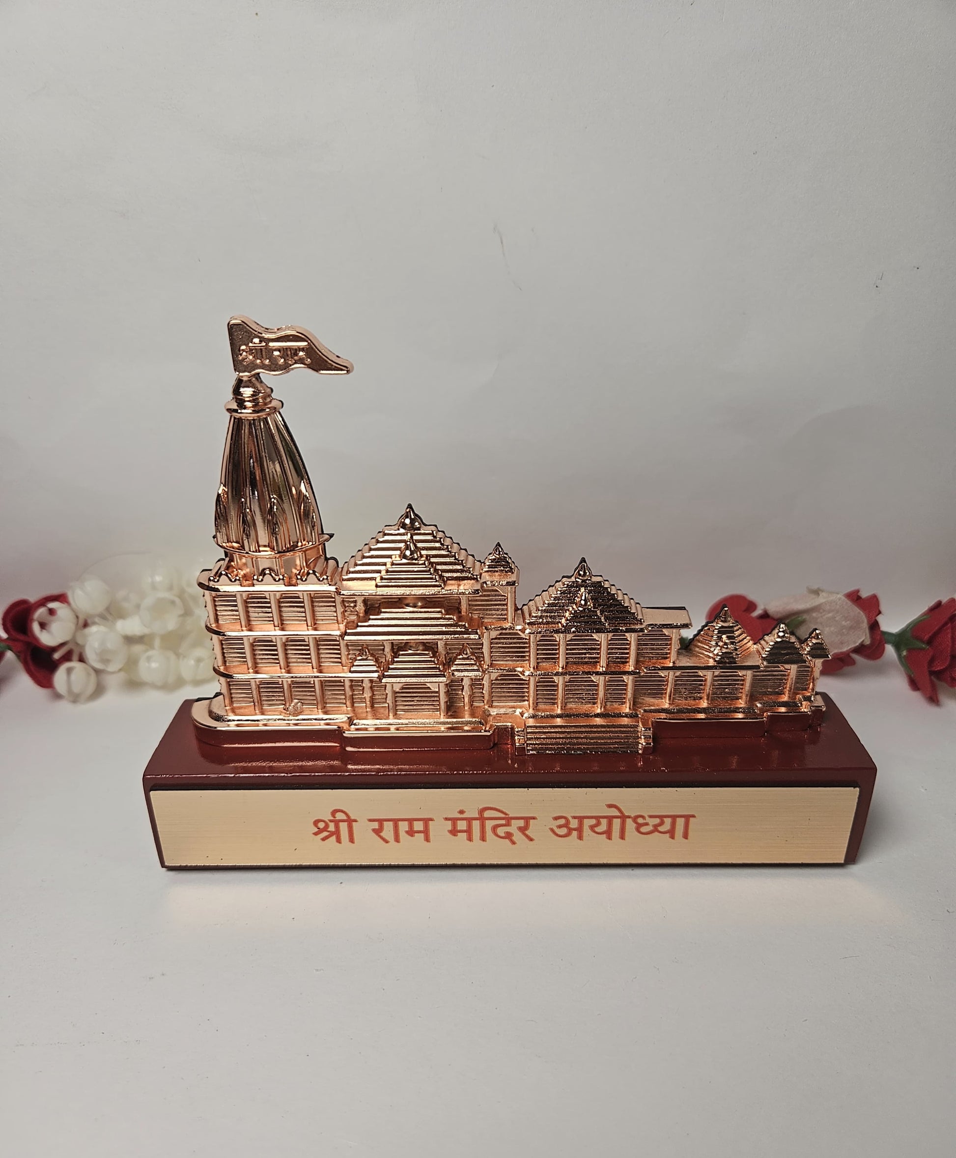 An idol depicting the Ram Mandir Ayodhya, presented as a finely crafted showpiece with a gleaming copper-toned appearance and a base bearing its name.