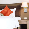 Rust Mudcloth Block Print Cushion Cover on the bed