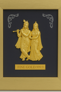 A framed golden relief sculpture of Radha and Krishna, standing side-by-side, with the text