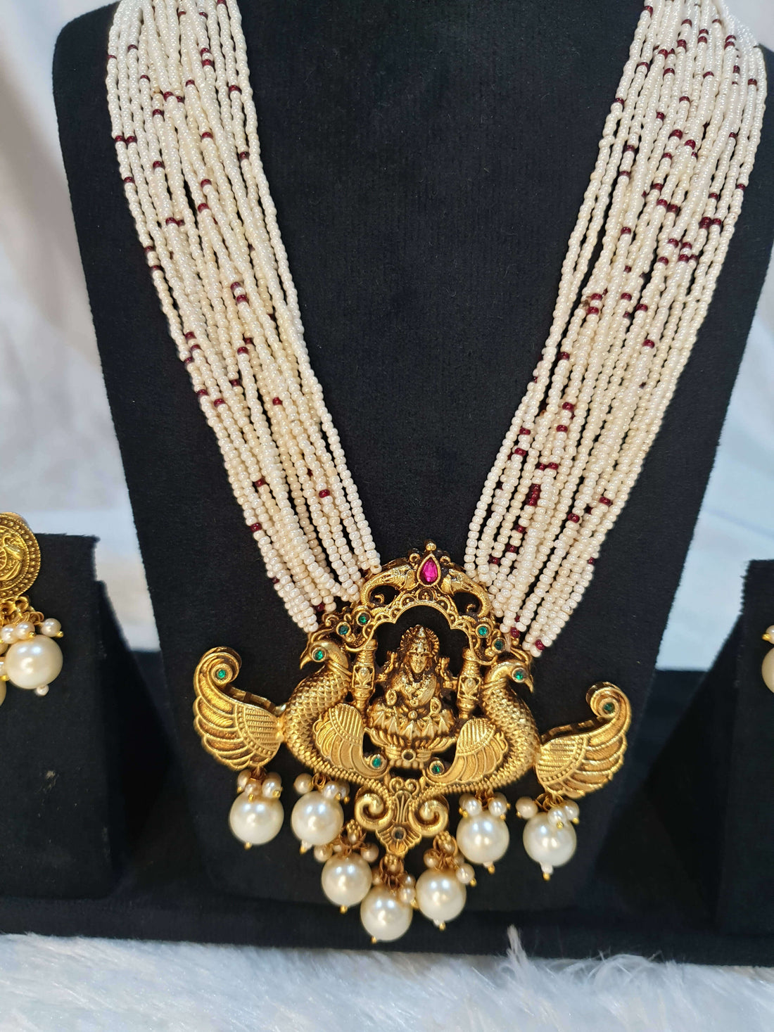 A display of traditional Indian jewelry, featuring earrings with gold accents and pearls.